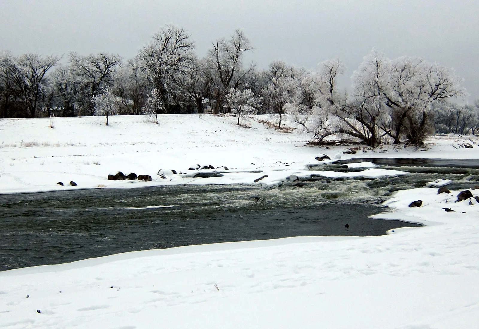 The Red River of the North bends through Fargo beneath a winter sky.